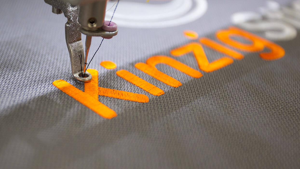 Orange bestickter Schriftzug „Kinzig“ auf Stoff