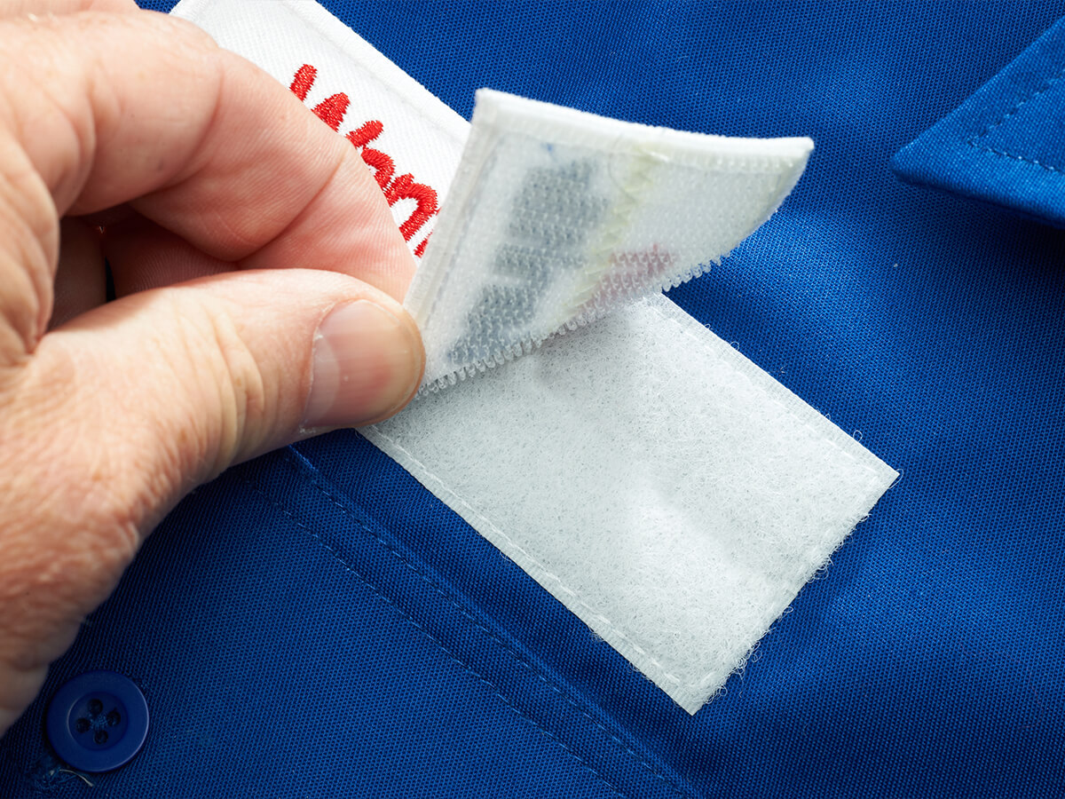 Klettpatch mit Stickerei auf blauer Workwear – Nacharbeit und Endkontrolle bei KinzigStick
